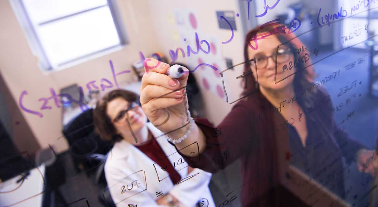 math students writing on a whiteboard