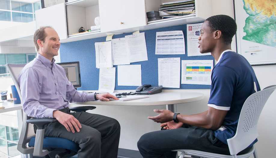 An advisor and student in an office deep in conversation