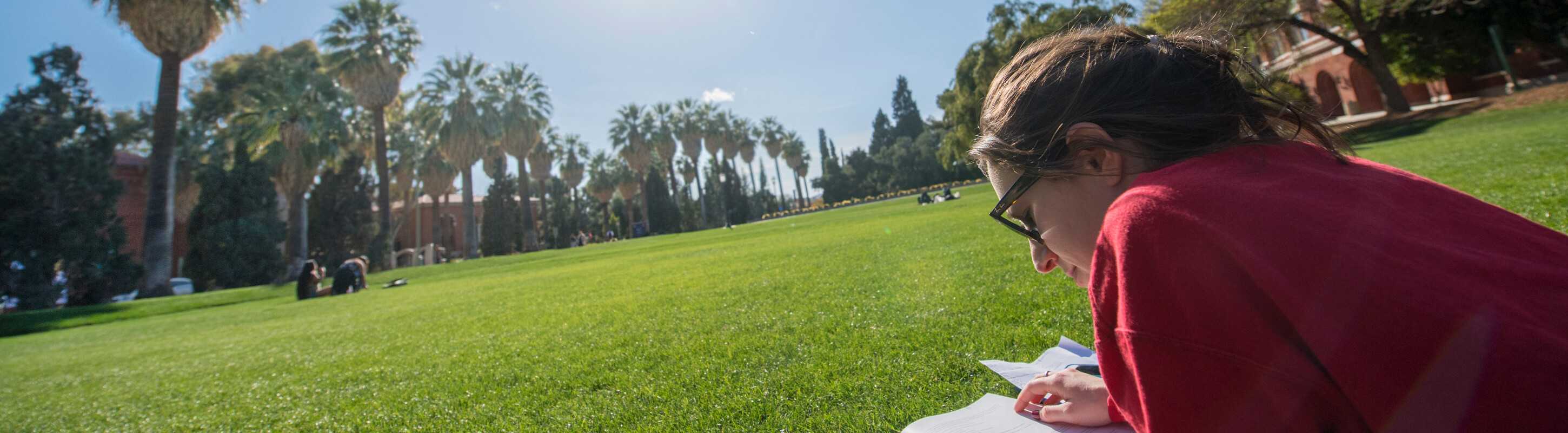 uarizona student reading in the grass