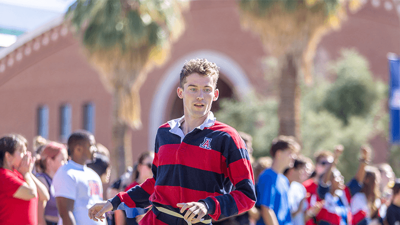 A University of Arizona student runs on the mall as part of a flag football competition.