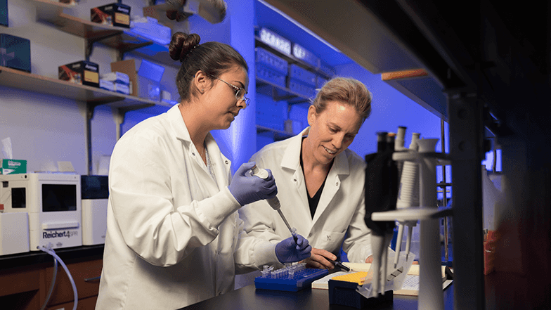 Student and professor in white lab coats