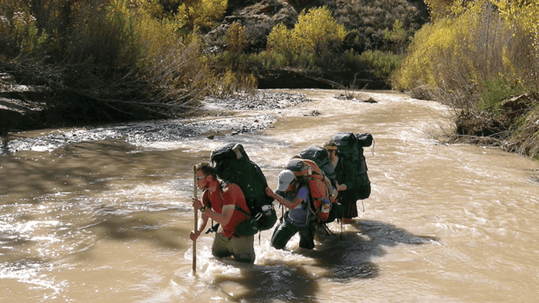 Club hiking through a river