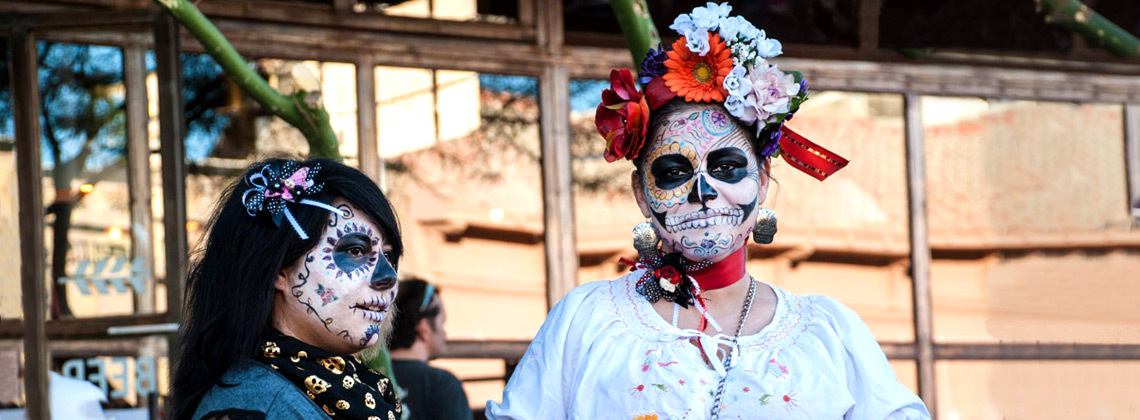 Women at All Souls Procession in Tucson with sugar skull makeup on their faces for day of the dead celebrations.