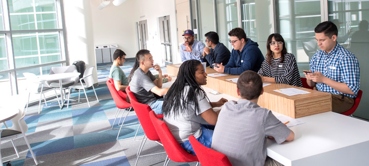 Students sitting in groups collaborating and getting involved in campus clubs.
