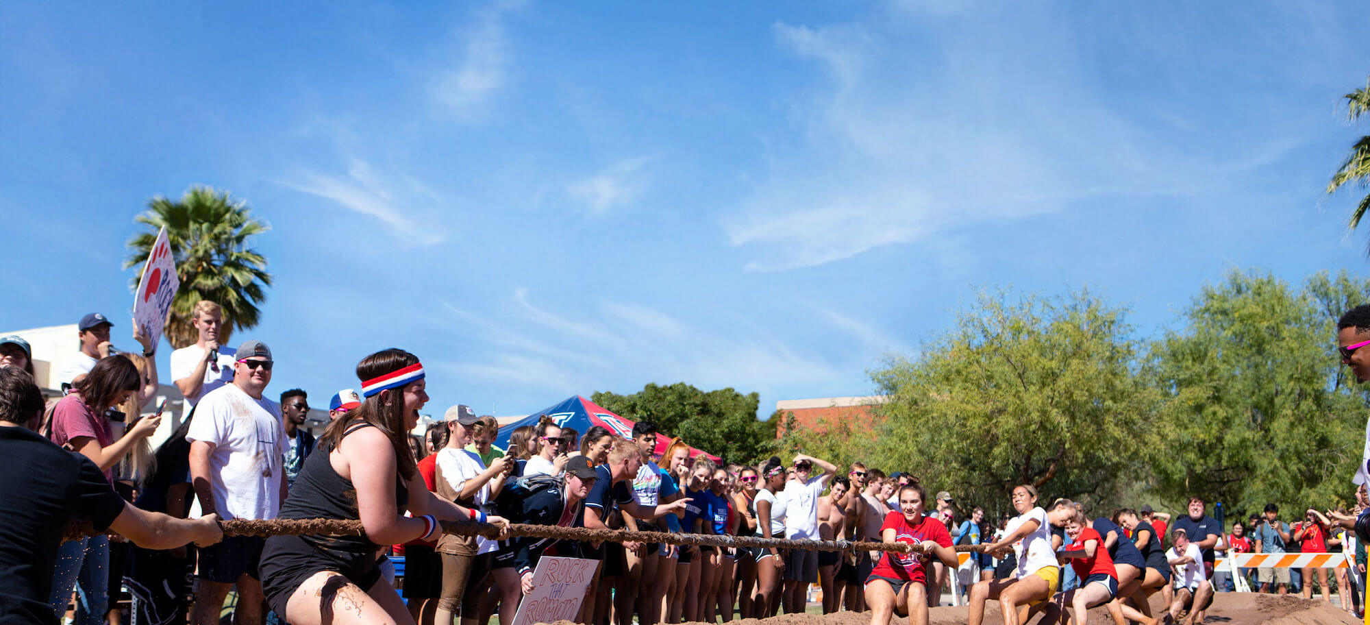 Teams of students playing tug-of-war over mud as part of a tradition at the University of Arizona.