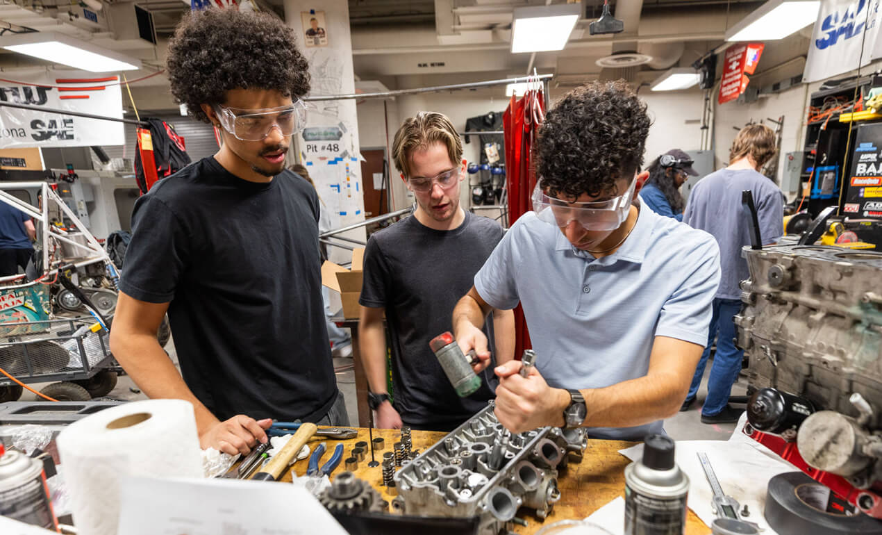 three men working in a auto shop
