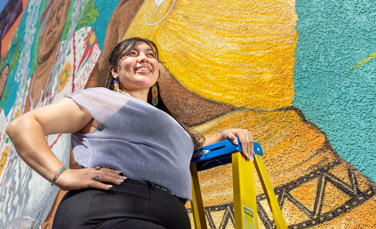 student painting a mural