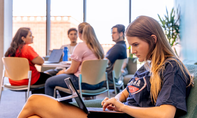 student doing homework on her laptop