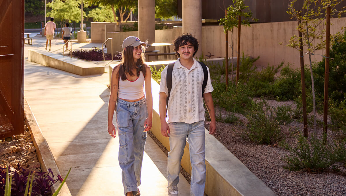 two students walking on campus to class