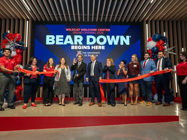 people holding a large ribbon while one cuts it with a large pair of scissors under a backdrop that reads "bear down begins here"