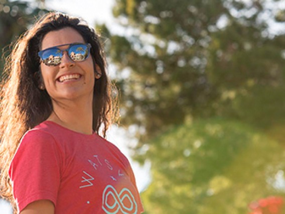 Female student wearing sunglasses with palm trees in background