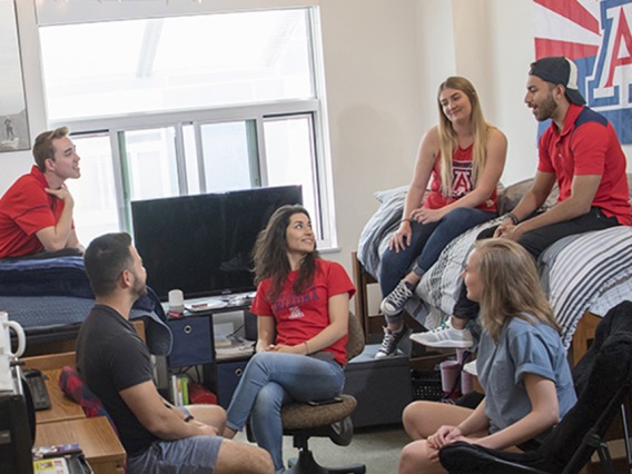 Group of students talking in a dorm room