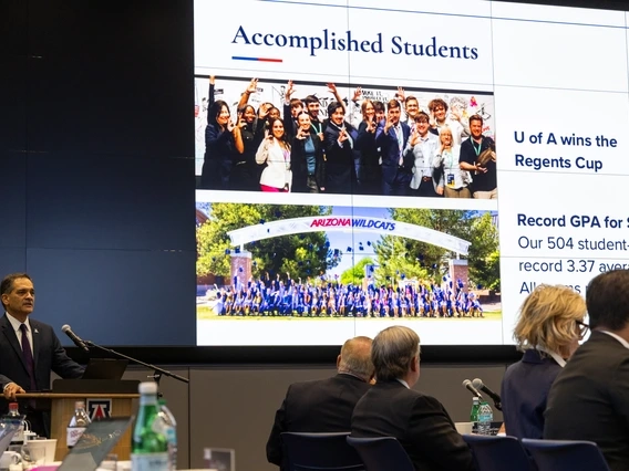 Suresh Garimella addressing the Arizona Board of Regents with a slide about student success behind him