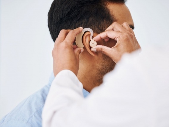 Man trying on hearing aid