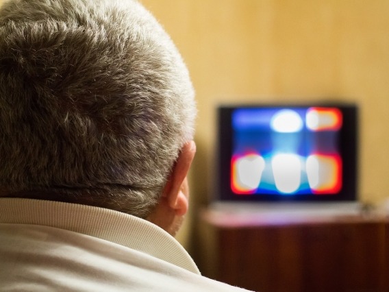 back of man&#039;s head watching TV