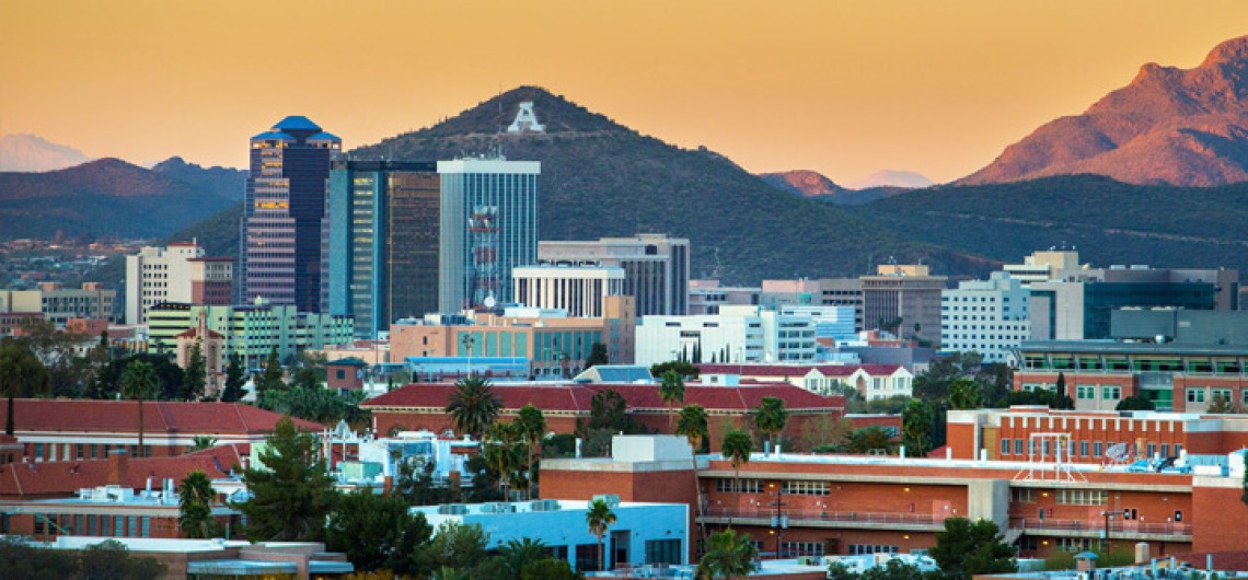 The skyline of Tucson, Arizona with A Mountain in the background at sunset.