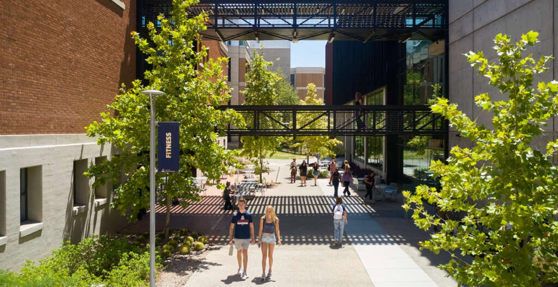 Students walking near a University of Arizona building outside on campus
